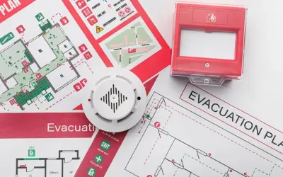 Piani di evacuazione e un rilevatore di fumo, elementi essenziali per la valutazione del rischio incendio.