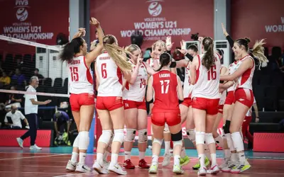 Drużyna siatkówki kobiet u21 świętuje zwycięstwo na Mistrzostwach Świata. Radość i entuzjazm po wygranej.