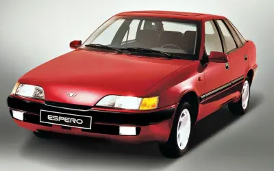 Czerwony Daewoo Espero z lat 90. na szarym tle. Klasyczny sedan, który wciąż budzi nostalgię.