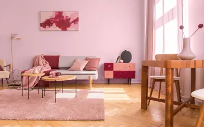 Salon w odcieniach brudny róż kolor. Sofa, dywan i zasłony tworzą przytulną atmosferę.