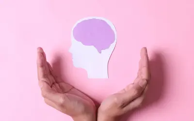 Dłonie otaczają profil głowy z mózgiem, symbolizując brak emocji po traumie i potrzebę wsparcia.