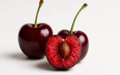 Ciliegie rosse, una tagliata a metà rivela il nocciolo. Sapevi che è qui che si trova la melatonina, aiutando il sonno?