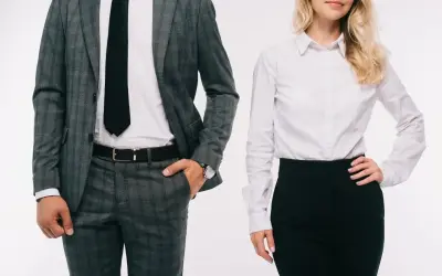 Elegancki mężczyzna w garniturze i kobieta w białej koszuli i czarnej spódnicy, prezentujący profesjonalny dress code.