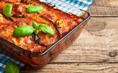 Parmigiana di melanzane in friggitrice ad aria, dorata e profumata, guarnita con basilico fresco. Un classico rivisitato per un risultato leggero e gustoso.