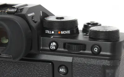 Część aparatu Fujifilm xt3 z pokrętłem wyboru trybu "STILL" i "MOVIE", przyciskiem "AF ON" i pokrętłem sterującym.