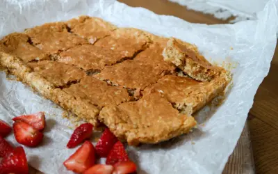Sega havrerutor på bakplåtspapper, med färska jordgubbar vid sidan om. Perfekt fika!