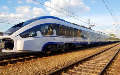 Nowoczesny pociąg PKP Intercity "Dart" na torach w Pabianicach, niedaleko Łodzi, gotowy do podróży.