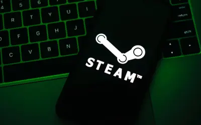Telefon z logo Steam na tle zielonej klawiatury.