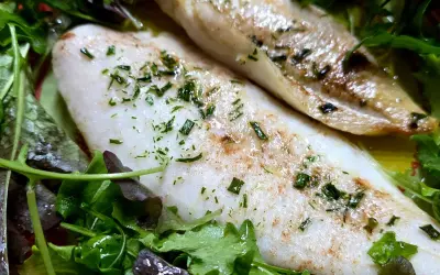 Delizioso merluzzo in friggitrice ad aria, cotto alla perfezione e servito su un letto di insalata fresca.