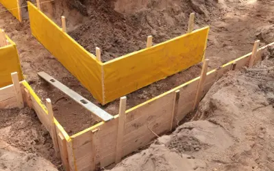 Wykonanie szalunku pod fundamenty z żółtą membraną i poziomicą.
