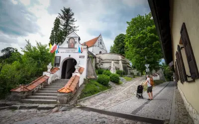 Droga do Sanktuarium Matki Bożej w Trzcińcu Lubelskim. Mężczyzna z wózkiem idzie brukowaną uliczką.