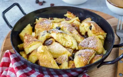 Kaiserschmarrn, fluffig und goldbraun, mit Rosinen und Puderzucker bestreut, zubereitet im Thermomix.