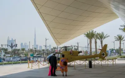 Luksusowe dubaj wczasy: ludzie podziwiają helikopter na tle drapaczy chmur.