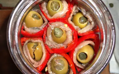 Peperoni sott'olio con acciughe e capperi, un antipasto saporito e colorato, pronto per essere gustato.