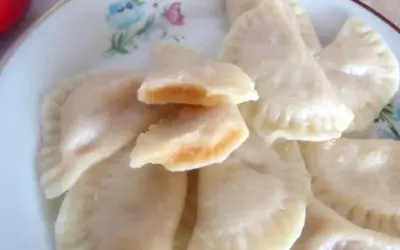 Pyszne pierogi z jabłkami, jeden rozkrojony ukazuje słodkie nadzienie.