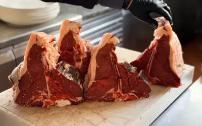 Maneggiare con cura la bistecca fiorentina a Firenze, pronta per essere grigliata.