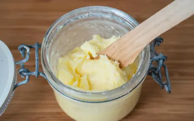 Frisch gemachte Butter in einem Glas, mit einem Holzspatel. So einfach kann man Butter selber machen!