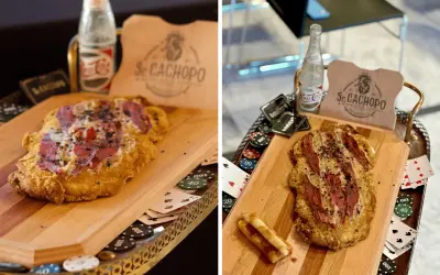 El cachopo Zaragoza, un plato crujiente con jamón y queso, servido con fichas de póker y una botella de refresco.