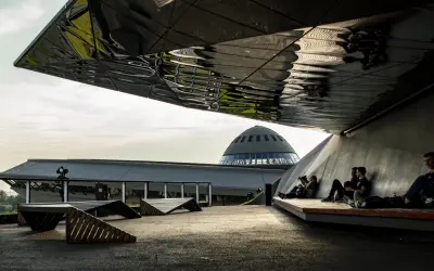 Nowoczesna architektura i ludzie odpoczywający pod zadaszeniem. W tle kopuła Muzeum Śląskiego, jedna z głównych katowice atrakcje.