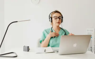 Lekarka w słuchawkach z mikrofonem wyjaśnia pacjentowi przez internet, jak stosować antybiotyk 3 dniowy.