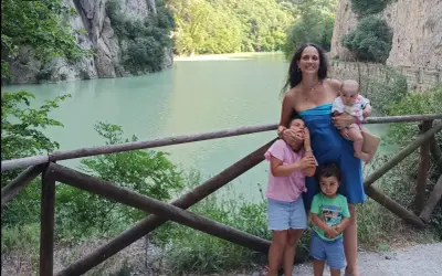 Famiglia felice nella Gola del Furlo, con un lago turchese e rocce imponenti.