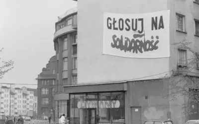 Transparent baner "Głosuj na Solidarność" na budynku, symboliczny protest przeciwko komunizmowi.