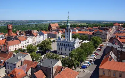 Widok na rynek i ratusz w Gąsawie. W tle widać wieżę ceglaną i rzekę. To jedne z wielu gąsawskich atrakcji.