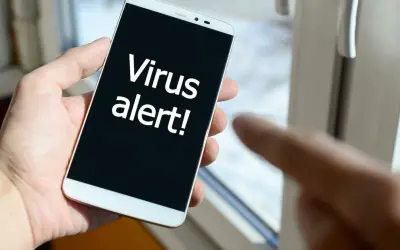 Dłoń trzyma smartfon z napisem "Virus alert!". Szukasz najlepszego darmowego antywirusa na Androida, by uniknąć takich komunikatów.
