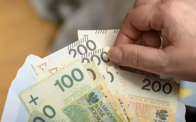 Dłoń trzyma polskie banknoty 100 i 200 zł. Wkrótce renta wdowia 2026.