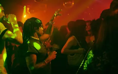 Persone che ballano in un locale notturno, luci stroboscopiche e musica alta: il vero clubbing significato.
