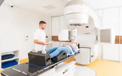 Frau liegt auf Behandlungsliege für Prostata-Bestrahlung. Arzt überwacht den Vorgang. Alkohol ist hier fehl am Platz.