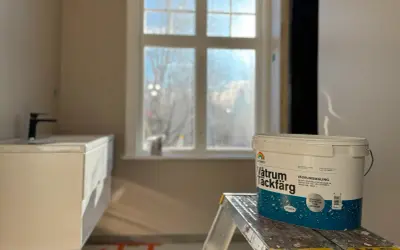 En hink med Beckers Våtrum Täckfärg står på en stege i ett badrum under renovering. Följ regler för att måla i badrum.