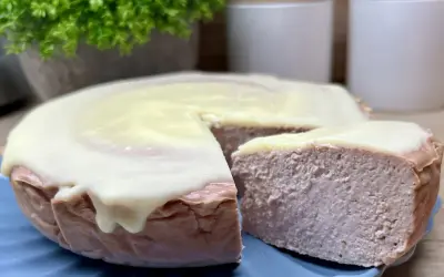 Pyszny sernik z malinami, oblany kremowym lukrem, kusi swoim wyglądem. Idealny na deser.