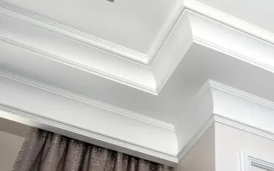 Eleganckie sztukaterie sufitowe, które skutecznie maskują karnisz, dodając wnętrzu klasy.