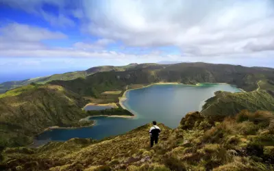 Ein Mann blickt auf eine atemberaubende Kraterlandschaft mit mehreren Seen. Die Frage, ob Madeira zu den Azoren gehört, wird hier durch die Schönheit der Natur beantwortet.