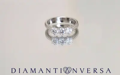 Un anello prezioso con tre diamanti scintillanti, riflesso su una superficie lucida.
