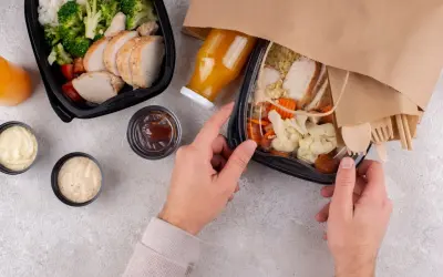 Dwa pudełka z jedzeniem na wynos: kurczak z ryżem i warzywami, sosy, sok. Idealny lunch co to?