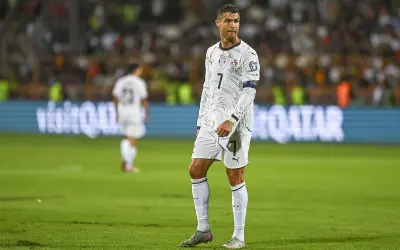 Cristiano Ronaldo w białej koszulce z numerem 7 na boisku piłkarskim.