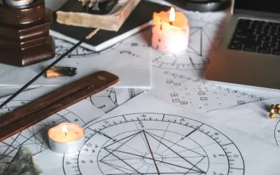 Świece i kadzidełka tworzą mistyczną atmosferę wokół kart astrologicznych. 11 dom astrologia w centrum uwagi.