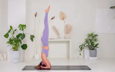 Donna in posa di Sirsasana, una delle inversioni yoga più conosciute.