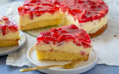 Ein saftiger Erdbeer Schmand Kuchen mit frischen Erdbeeren und glänzendem Tortenguss. Ein Stück auf einem Teller mit Gabel.