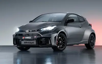 Szary Toyota GR Yaris z czarnymi felgami i czerwonymi zaciskami hamulcowymi, gotowy do akcji.