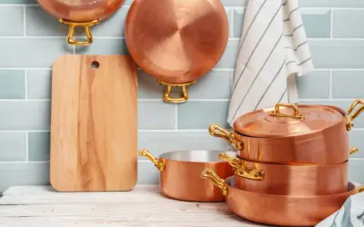 Utensilios de cobre apilados y colgados, listos para aprender como limpiar el cobre y mantenerlos brillantes.