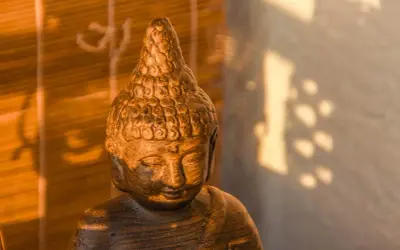 Posąg Buddy w cieniu, symbolizujący pozytywne skutki modlitwy dla zdrowia psychicznego i fizycznego, potwierdzone dowodami naukowymi.