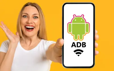 Mujer sorprendida muestra un teléfono con el logo de Android y "ADB" escrito, indicando control remoto.