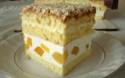 Pyszne ciasto z brzoskwiniami i kremem, posypane wiórkami kokosowymi. Wygląda jak bogini Wenus na talerzu.
