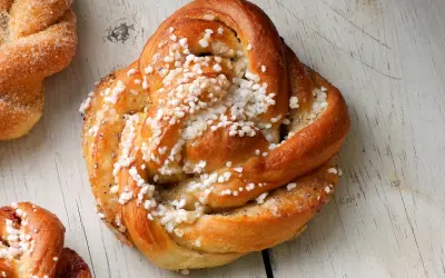 Gyllene kardemummabullar med pärlsocker, redo att bakas enligt ett enkelt kardemummabullar recept.