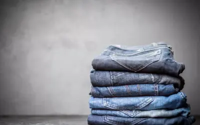 Stosik złożonych jeansów, każdy w innym odcieniu niebieskiego. Z czego jest jeans? Z bawełny, tkanej diagonalnie, co nadaje mu wytrzymałość.
