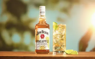 Butelka Jim Beam Pineapple i drink z limonką. Sprawdź, ile procent ma ten słodki, tropikalny likier.