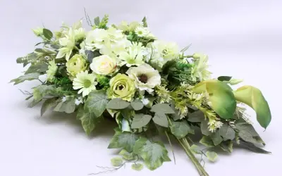 Elegancki bukiet z białych i zielonych kwiatów, idealny jako ozdoba na cmentarz.